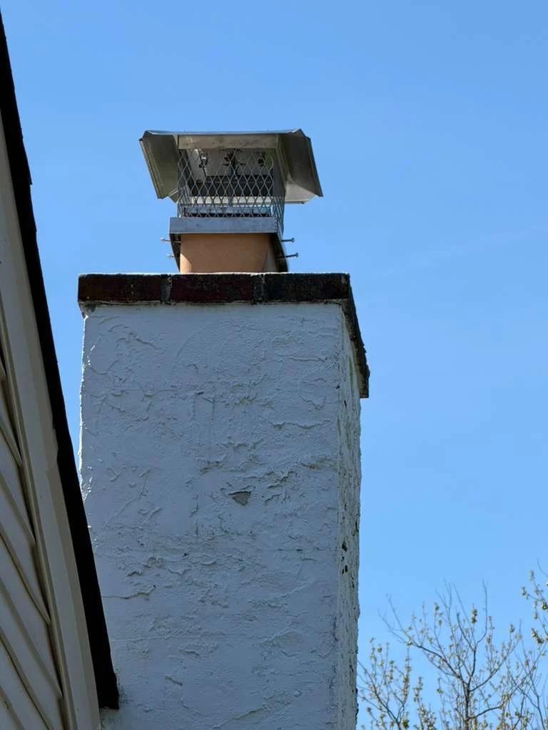 Chimney cap installed on a stucco chimney