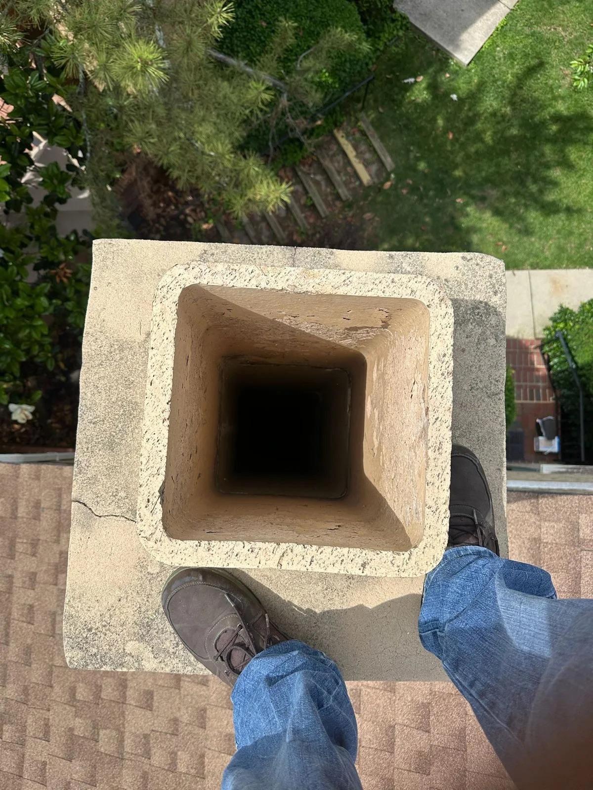 Technician inspecting down a chimney flue liner